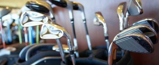 Golf bags with clubs in sporting goods store