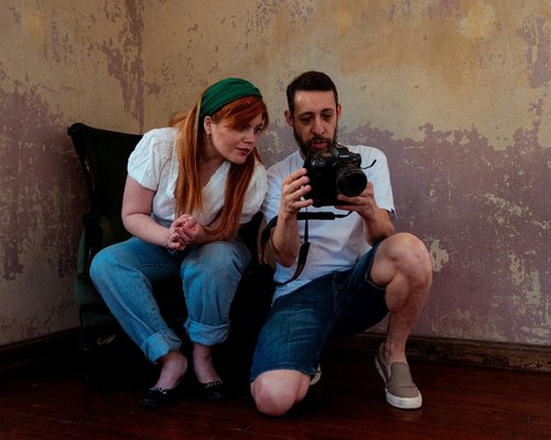 A photographer and assistant reviewing images together indoors.