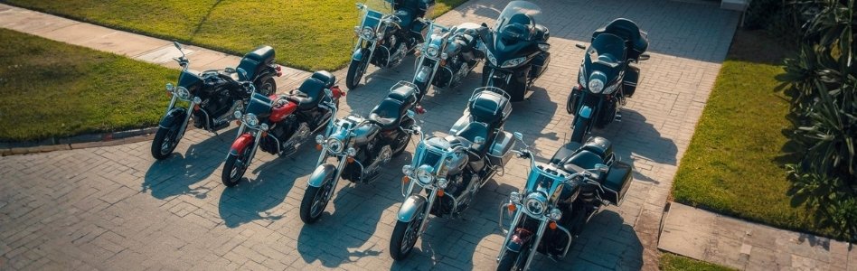an image showcasing different types of motorcycles. Have them placed in the driveway of a residential area